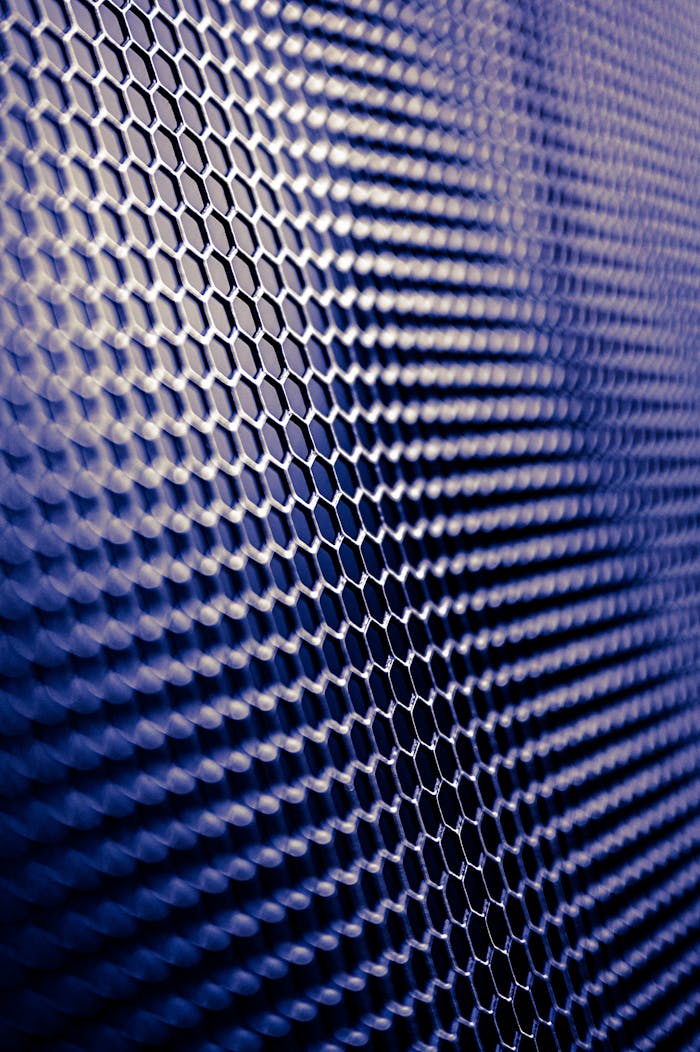 who-we-are Close-up of a futuristic metallic hexagonal pattern, perfect for tech designs.