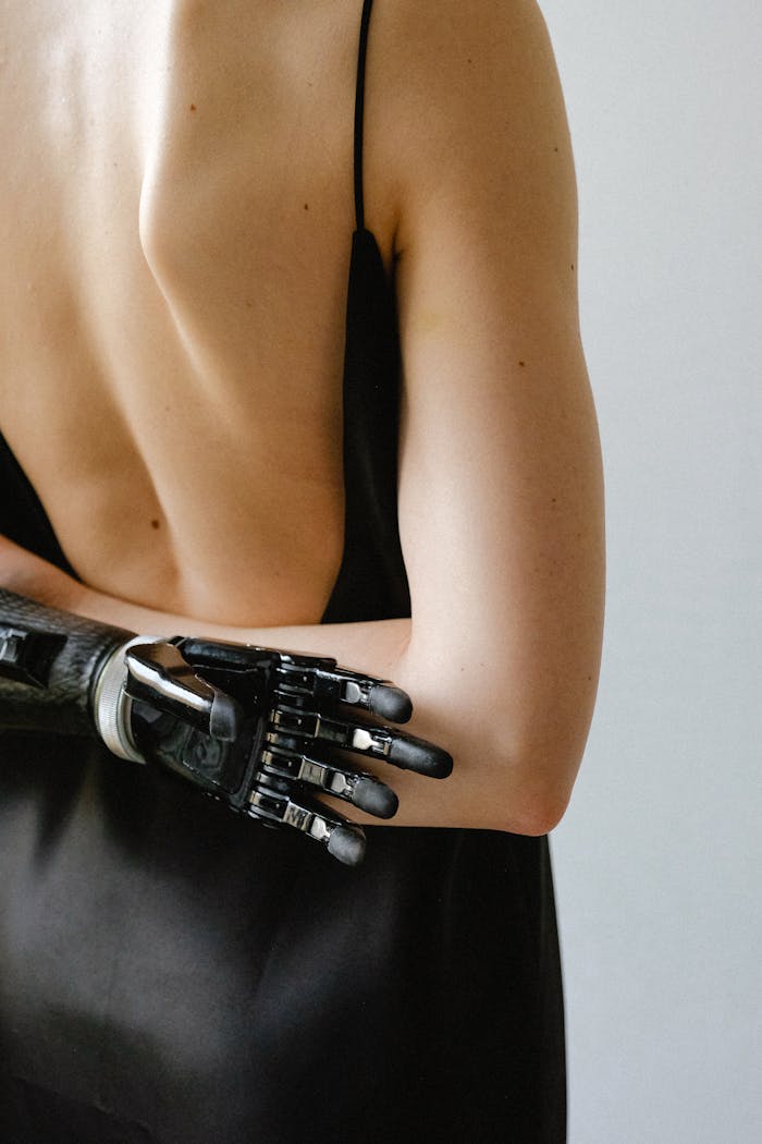 Mastering the First Impression: Your intriguing post title goes here Stylish woman with a prosthetic arm in a black dress, showing empowerment and technology